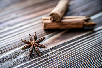 Star anise and cinnamon on a wooden surface.