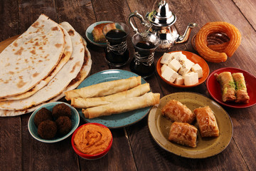 Middle eastern or arabic dishes and assorted meze, concrete rustic background. Turkish Bread or Turkish pizza. Dessert Baklava with pistachio. falafel with hommos.  Halal food. Lebanese cuisine