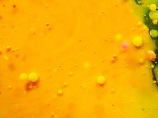 Abstract yellow background. Close up macro shot of bubbles and paint drops. Blurred background. Selective soft focus. Yellow spheres and spots. Pattern of abstract universe
