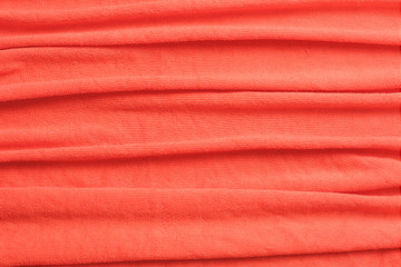 Modern fabric background or mock up with space for text. Texture of cloth in coral color of the year 2019