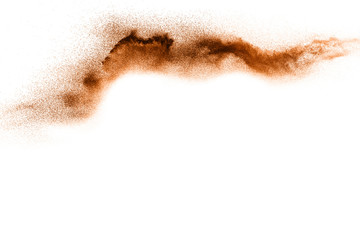 Brown particles splattered on black background. Brown dust splashing.