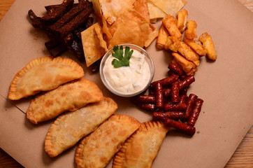 Tortilla chips garnished with ground beef, melted cheese, peppers and cilantro leaves in plate on...