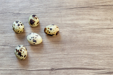 Fototapeta premium Quail eggs on brown wooden background. Flat lay, top view. Easter concept.