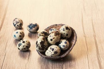 Quail eggs on brown wooden background. Flat lay, Easter concept.