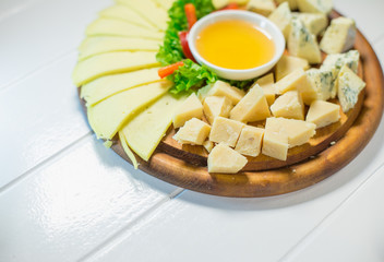 Delicious cheese on the table with honey and vegetables