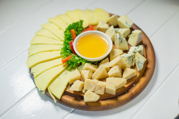 Delicious cheese on the table with honey and vegetables