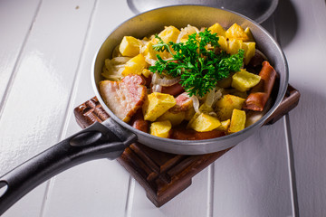 fried egg with sausage and potato in a frying pan