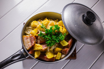 fried egg with sausage and potato in a frying pan