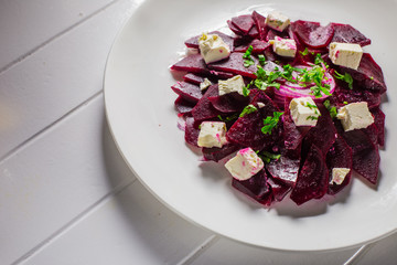 Vitamin salad with beets and Feta cheese in a white plate