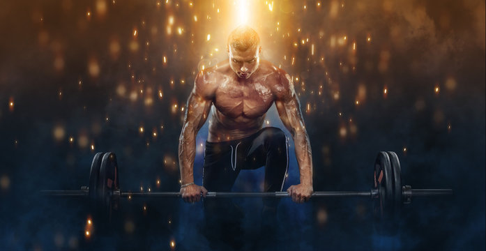 Photo of strong muscular bodybuilder athletic man pumping up muscles with barbell on fire background. Workout energy bodybuilding concept.