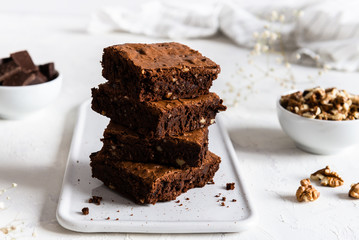 homemade chocolate brownies with walnuts on white background, side view
