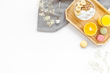 Healthy granola, macaroons and orange juice for colorful breakfast on white background top view mock-up