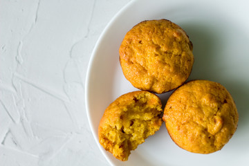 homemade orange pumpkin muffins on a white plate. copy space. the view from the top.