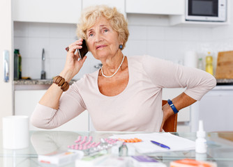 Woman among medicines talking on phone