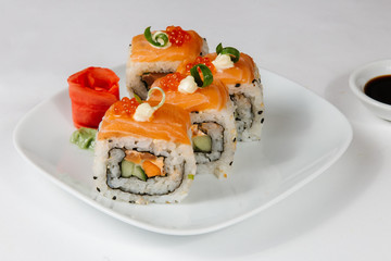 The concept of Japanese and Chinese cuisine. Sushi rolls laid out on a plate and soy sauce.