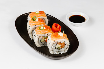 The concept of Japanese and Chinese cuisine. Sushi rolls laid out on a plate and soy sauce.