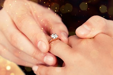 Close up Groom Putting the Wedding Ring on bride