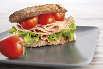 pane a fette e prosciutto con insalata verde e pomodori fronte altra vista