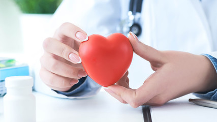 Female medicine doctor hold in hands red toy heart close -up. Cardio therapist student education concept - 257692002
