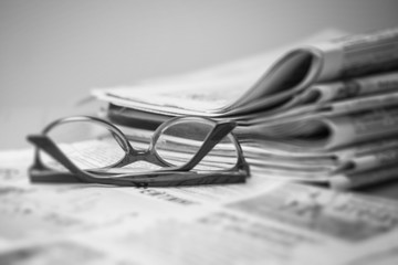 Newspapers on the desktop, eyeglasses. News concept