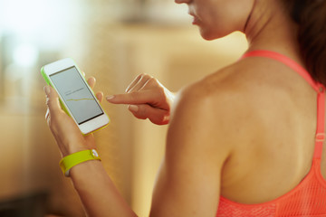 Closeup on smartphone screen with fitness app in hand of woman