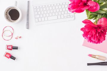 Flat lay blogger or freelancer workspace with a notebook, keyboard, red peonies on a white background