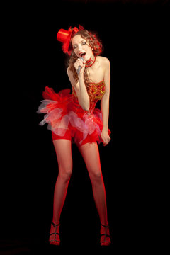 Sexy burlesque singer stripper in red corset and red hat with curly hair