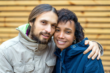 Couple in love are walking in the autumn park. Afroamerican girl with a European.