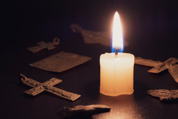 burning candle of paraffin after the tragedy on the background of Orthodox crosses and icons
