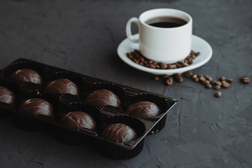 Chocolate cakes and cup of coffee on dark background
