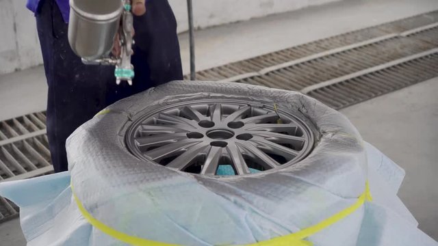 Wheel repair ,Automobile disc restoring. Painter painting light alloy wheel with spray