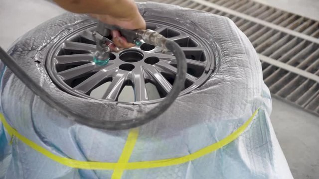 Wheel repair ,Automobile disc restoring. Painter painting light alloy wheel with spray