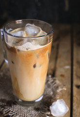Close-up of ice coffee in a glass on wooden background 