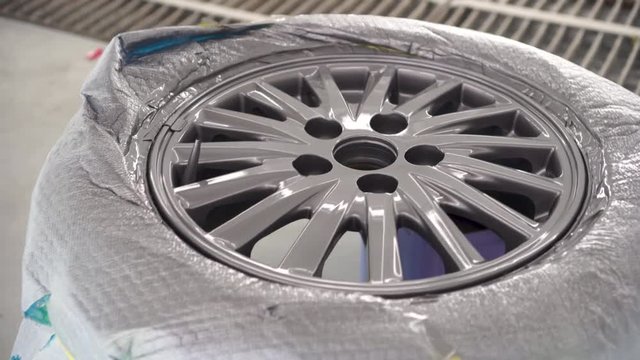 Wheel repair ,Automobile disc restoring. Painter painting light alloy wheel with spray