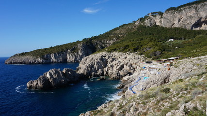 Stone beach at the mediterranean sea near the lighthouse on the island of capri
