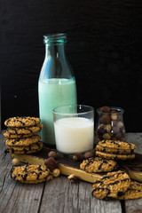 Chocolate cookies and milk on wooden table. Chocolate chip cookies shot