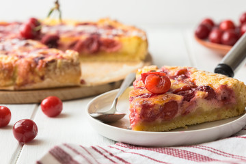 Clafoutis cherry pie on wooden background. Klafuti french cherry pie.