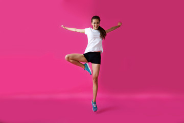 Fototapeta na wymiar girl sportsman posing on a pink background