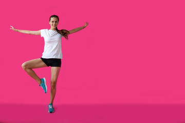 girl sportsman posing on a pink background