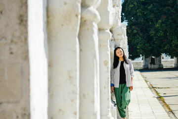 Obraz na płótnie Canvas single Asian girl leans on white pagoda at Kuthodaw Pagoda, Mandalay, Myanmar