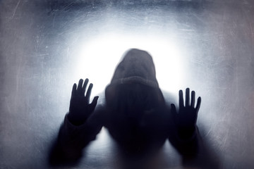 Ghostly figure behind a dusty scratched glass