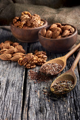 Food ingredients in wooden spoon on wooden background. Flax, pumpkin seed, sunflower and sesame.