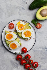 Sandwich on grain bread with boiled egg and avocado on plate