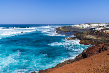 Fototapeta na wymiar Spain, Lanzarote, Rough west coast waves at little fishing village of el golfo