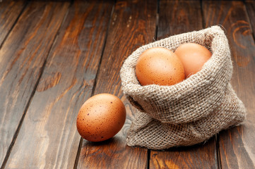  eggs in burlap sack on an old wooden background