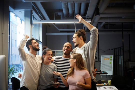 Male and female entrepreneurs cheering in creative office