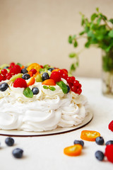 Pavlova cake with cream and fresh summer berries. Close up of Pavlova dessert with forest fruit and mint
