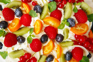 Pavlova cake with cream and fresh summer berries. Close up of Pavlova dessert with forest fruit and mint.