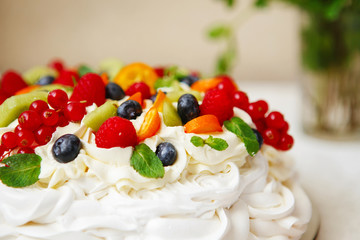 Pavlova cake with cream and fresh summer berries. Close up of Pavlova dessert with forest fruit and mint.