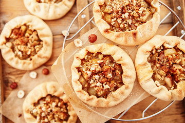 Caramelized pear rustic pie on wooden background, top view.
